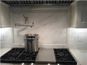 Imperial Danby Marble Countertops, with Full Height Slab Backsplash Behind Cooktop, Custom Rail Detail for Surrounding Edge Imperial Danby Marble Countertops, with Full Height Slab Backsplash Behind Cooktop, Custom Rail Detail for Surrounding Edge